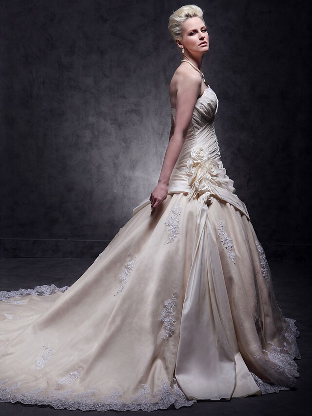 Close-up of beaded lace and appliques on wedding dress.