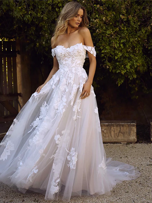Full view of an A-line wedding dress with a sweetheart neckline, cap sleeves, lace appliques, and a court train.