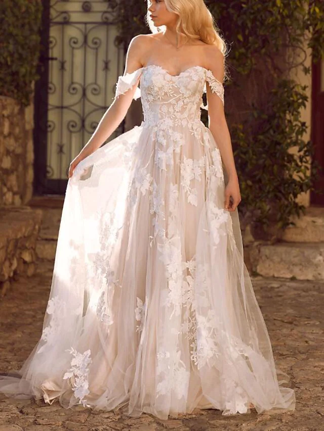 Side view of the A-line wedding dress, showcasing the flowing tulle skirt and elegant court train.