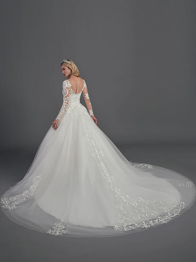 Close-up of the illusion neckline and lace detailing on the long sleeves of the wedding dress.