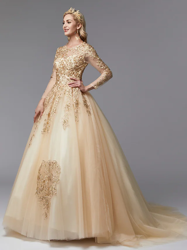 Full view of a glamorous white ball gown wedding dress with a jewel neck, long lace sleeves, and intricate beading.