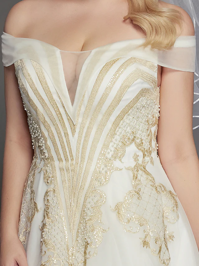 Bride posing gracefully in the off-shoulder lace and tulle wedding dress.