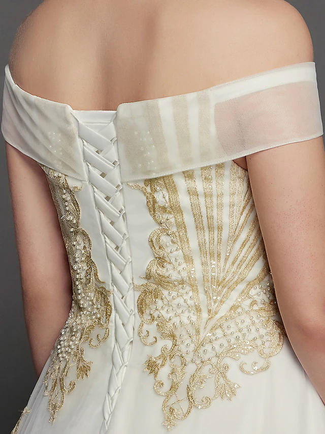 Detail of the cap sleeve and off-shoulder neckline of the wedding dress.