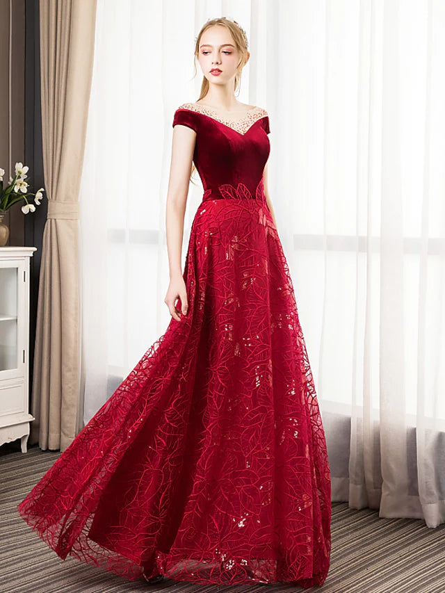Model wearing a glittering A-line prom dress with jewel neck and short sleeves.