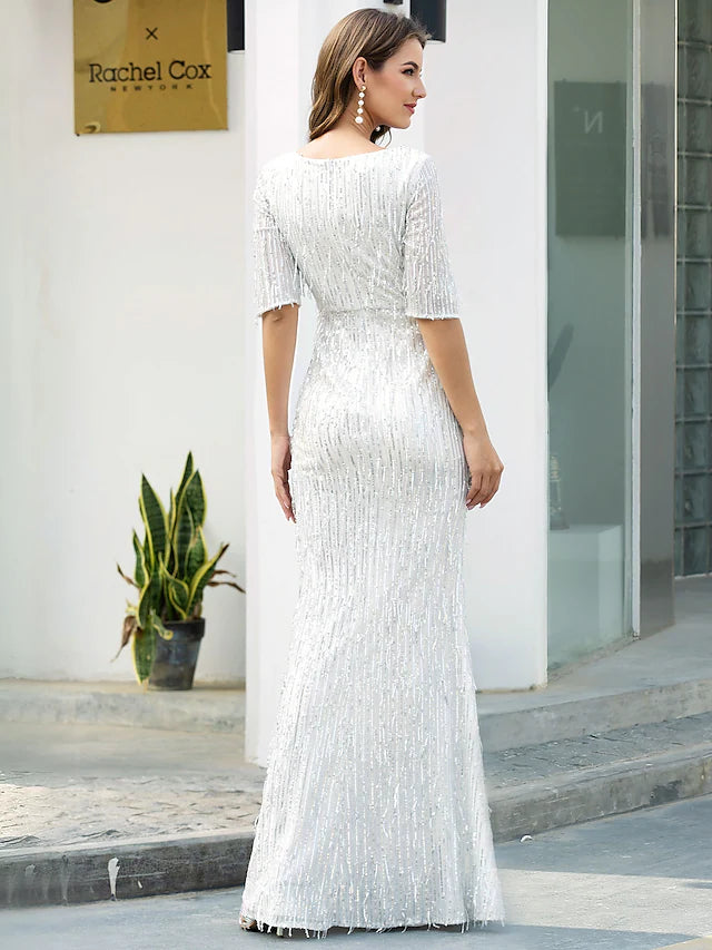 Woman posing in a glittering gold sheath evening gown, highlighting the elegant silhouette.