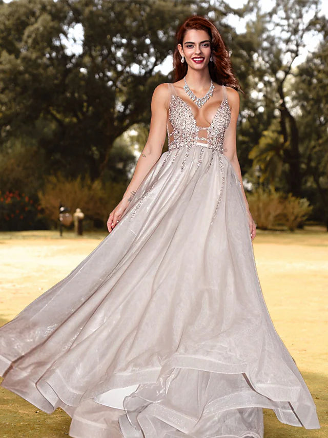 Model wearing a sparkling A-line V-neck sequined prom dress with a backless design.