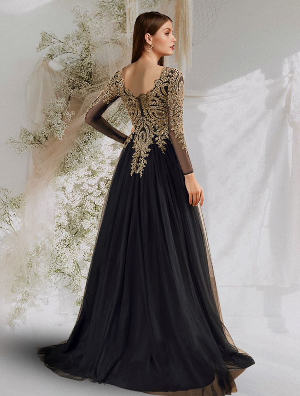 Back view of the navy V-neck long sleeve ball gown, showcasing the floor-length tulle skirt.
