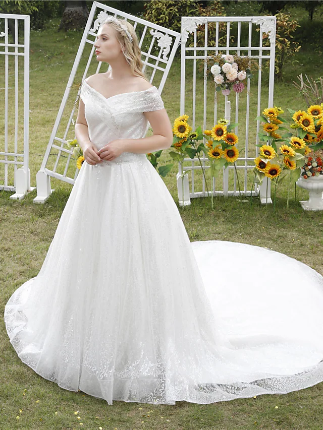 Back view of a sparkling off shoulder wedding dress with cathedral train.