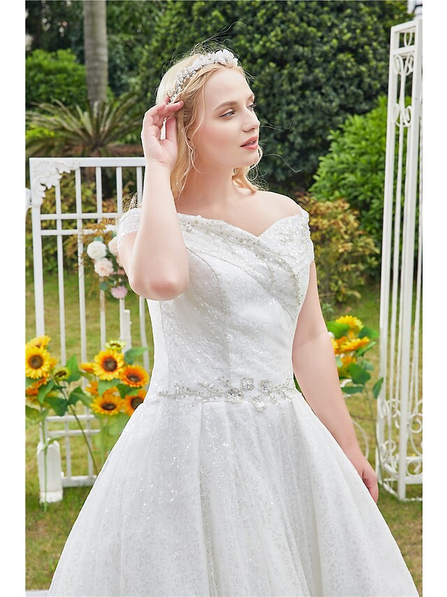 Full length view of a romantic off shoulder wedding dress.