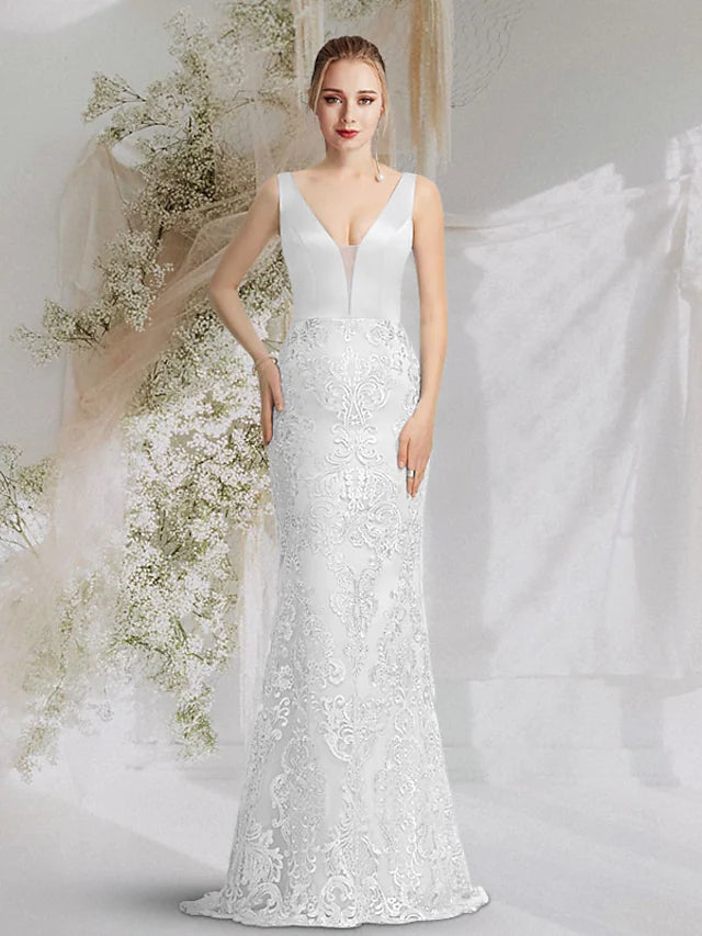 Woman wearing a luxurious blue V-neck sleeveless mermaid trumpet prom dress with an overskirt and appliques.