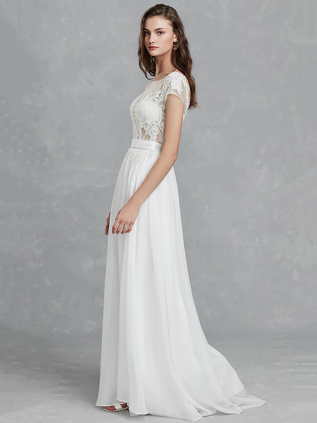 Side profile of a bride wearing a long sleeve satin wedding gown with a bateau neckline.
