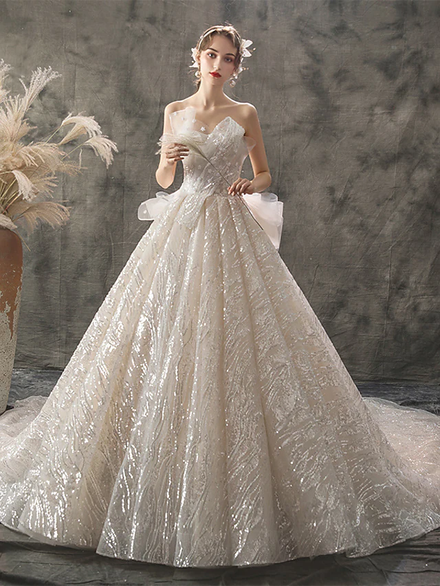 Princess strapless ball gown wedding dress with lace and sequins.