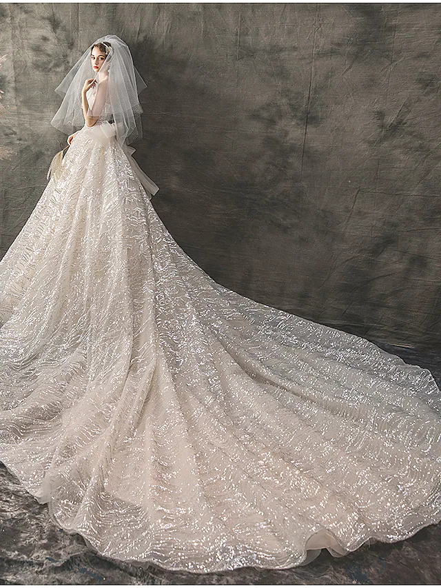 Close-up of lace and sequin details on a wedding dress.