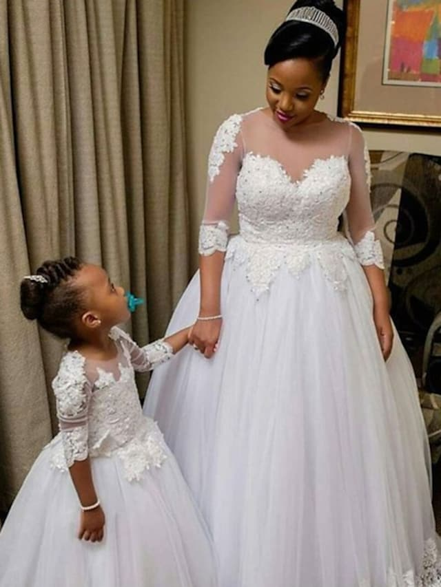 Model wearing a Princess A-Line wedding dress with jewel neck, lace, and tulle.