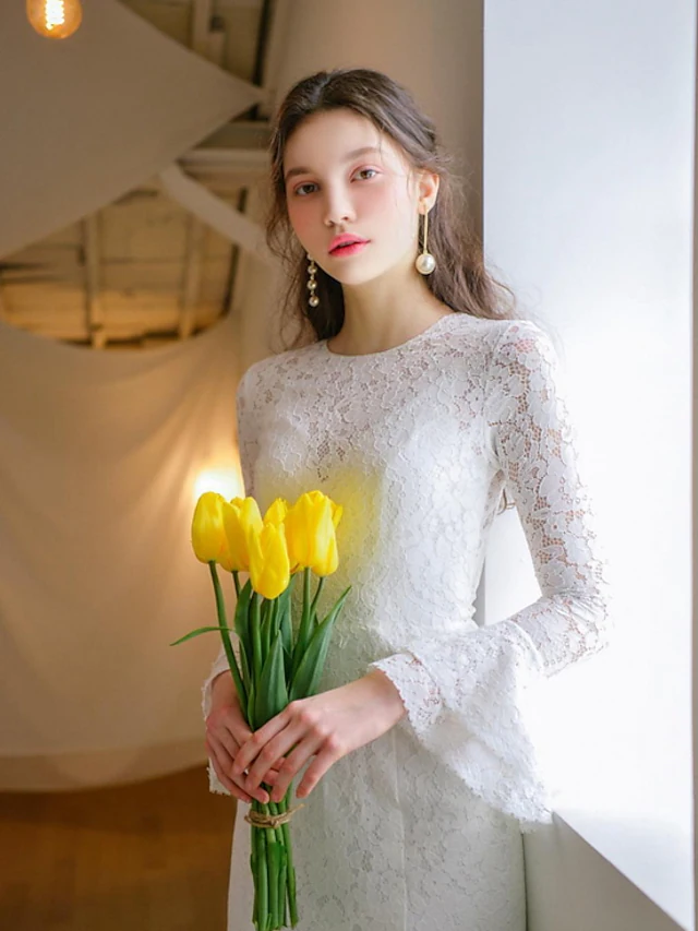 Side view of A-Line wedding dress, showcasing the flowing skirt and lace sleeves.