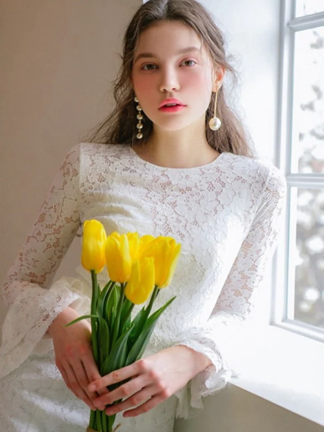 Close-up of delicate lace and applique details on the wedding dress bodice.