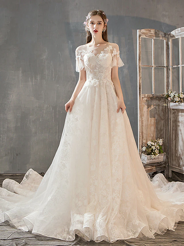 A-Line wedding dress with jewel neck and short lace sleeves.