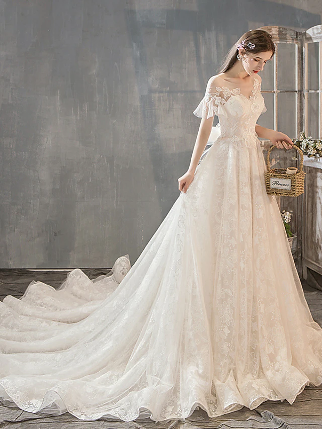 Close-up of jewel neck and short sleeve with lace and beading on wedding dress.