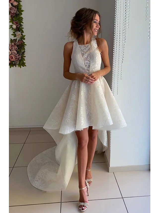 A-line wedding dress with jewel neck, lace appliques, and asymmetrical knee-length hem.
