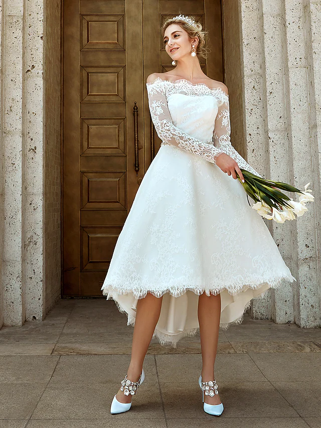 Detail of asymmetrical lace and crystal brooch on the bridal gown.