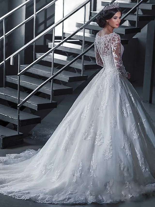 Back view of an A-line wedding dress with a court train, off-shoulder neckline, and intricate lace appliques.