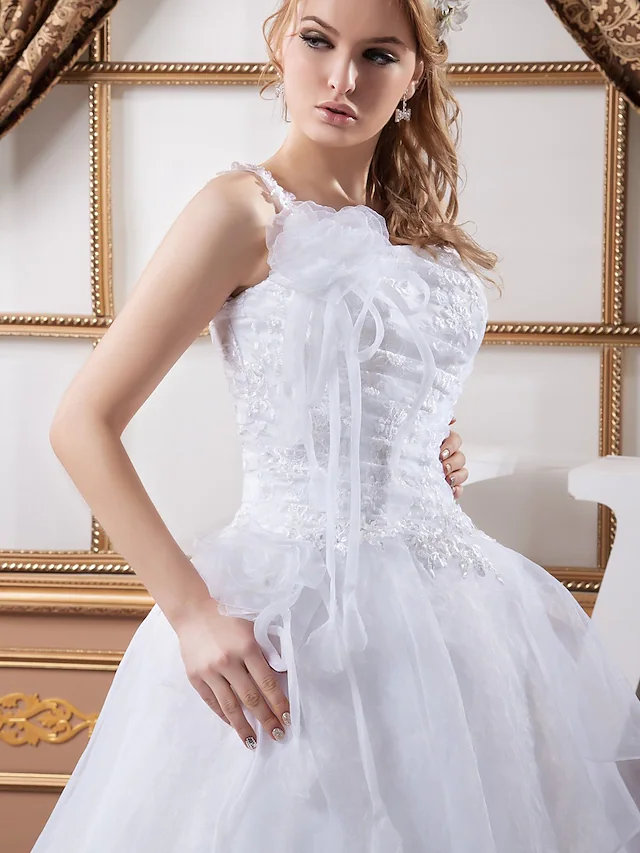 Close-up of one-shoulder neckline and spaghetti strap on wedding dress.
