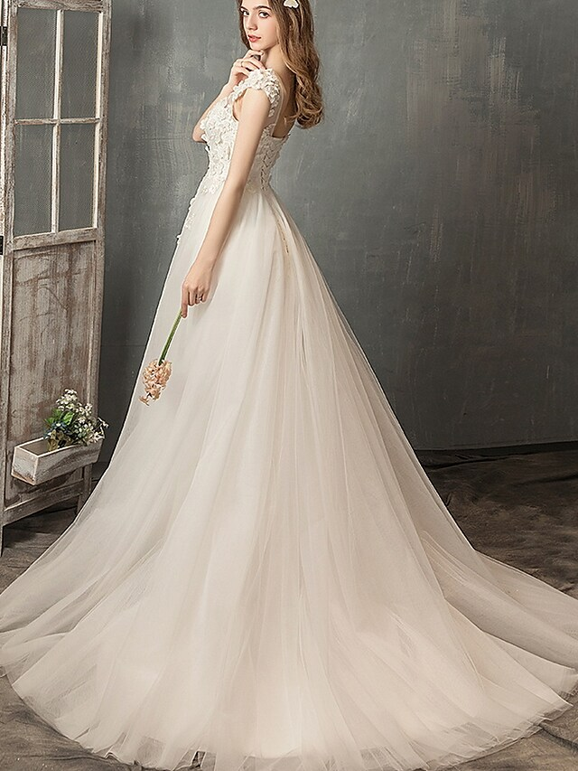 Side view of the A-line wedding dress, showcasing pleats and appliques.