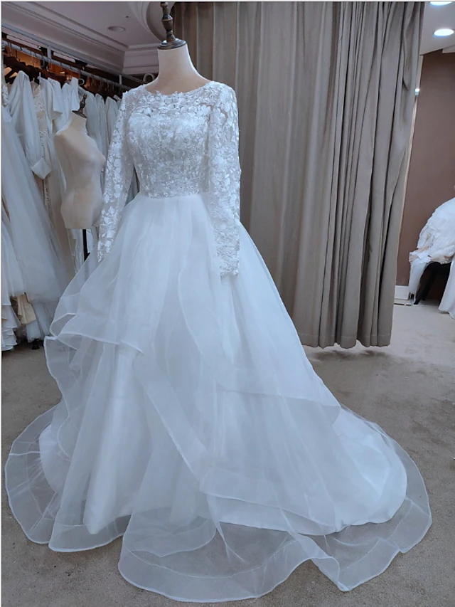 Elegant A-line wedding dress with jewel neck and long sleeves.