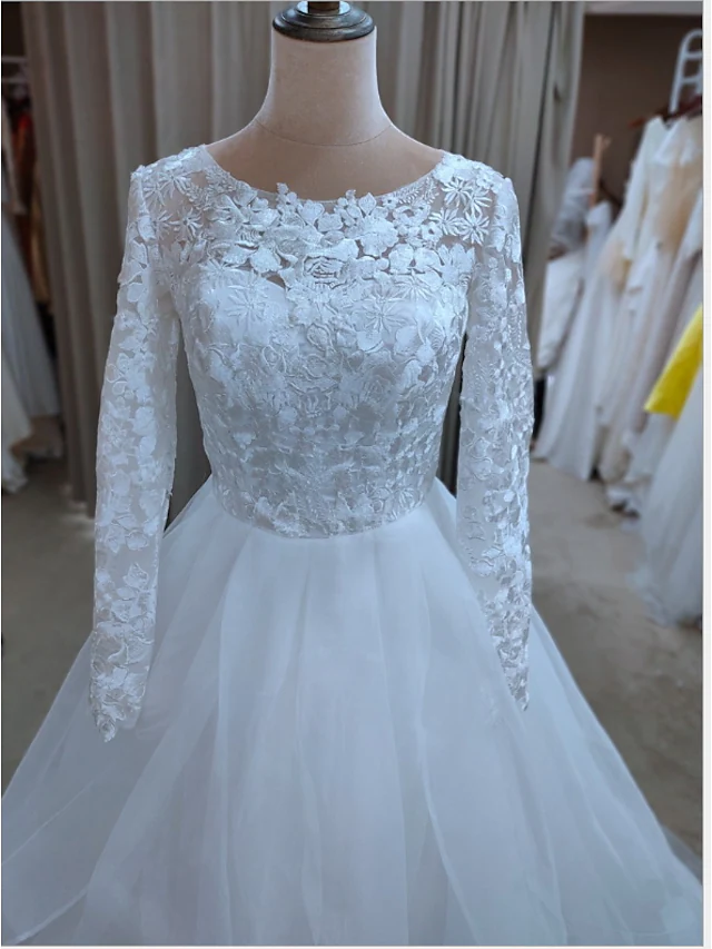 Close-up of jewel neck and lace appliques on wedding dress bodice.