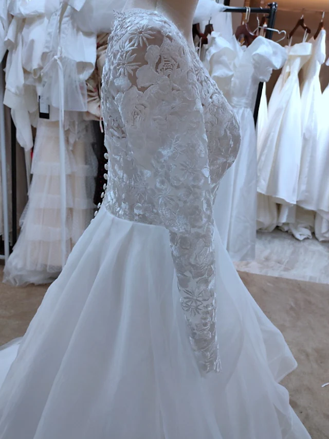 Back view of A-line wedding dress featuring a court train and cascading ruffles.
