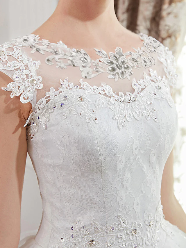 Close-up of the beading and lace patterns on the wedding dress fabric.