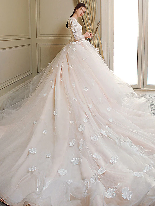 Princess ball gown wedding dress with jewel neck, long lace sleeves, and chapel train.