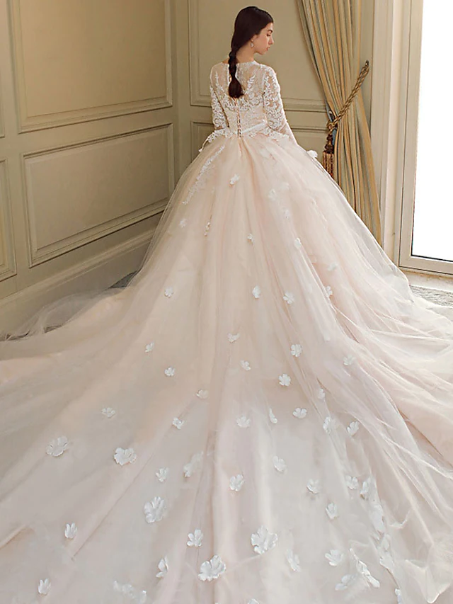 Close-up of the jewel neckline and delicate long lace sleeves on the wedding dress.