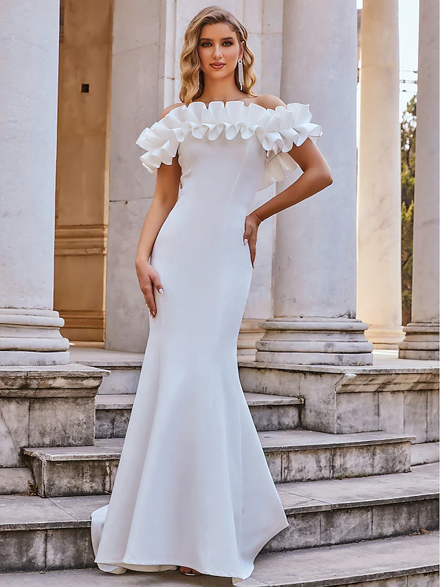 Bride in an elegant off-shoulder mermaid wedding dress with cascading ruffles.