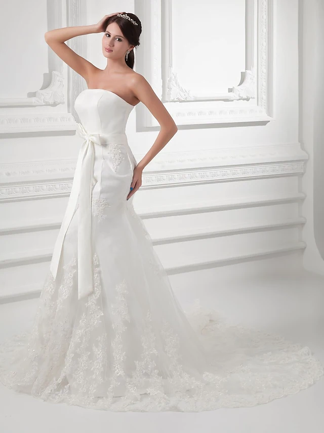 Elegant strapless A-line wedding dress with lace details and chapel train.