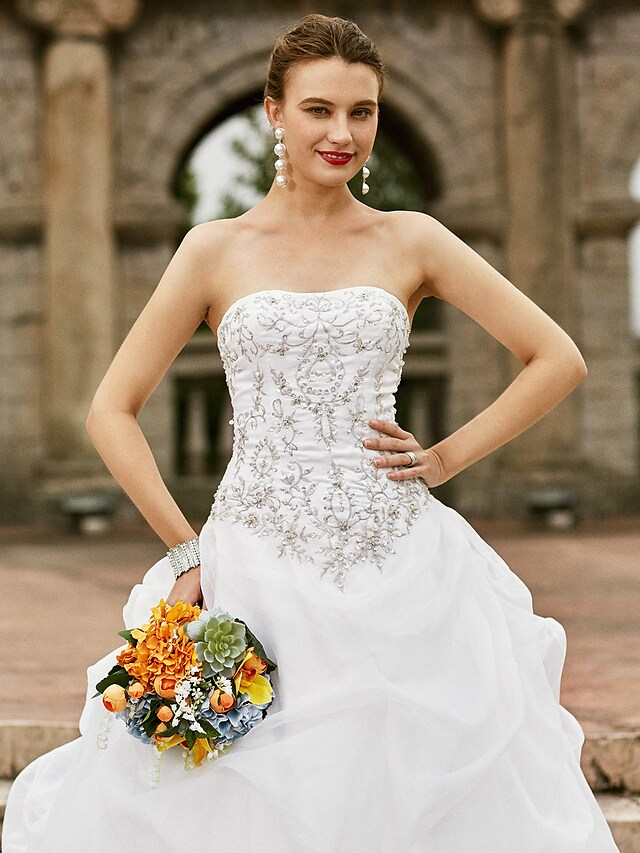 Back view of a strapless ball gown wedding dress, showcasing the elegant court train.