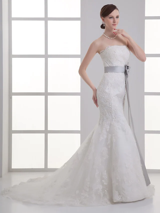 Back view of a bridal gown with chapel train and delicate beading.