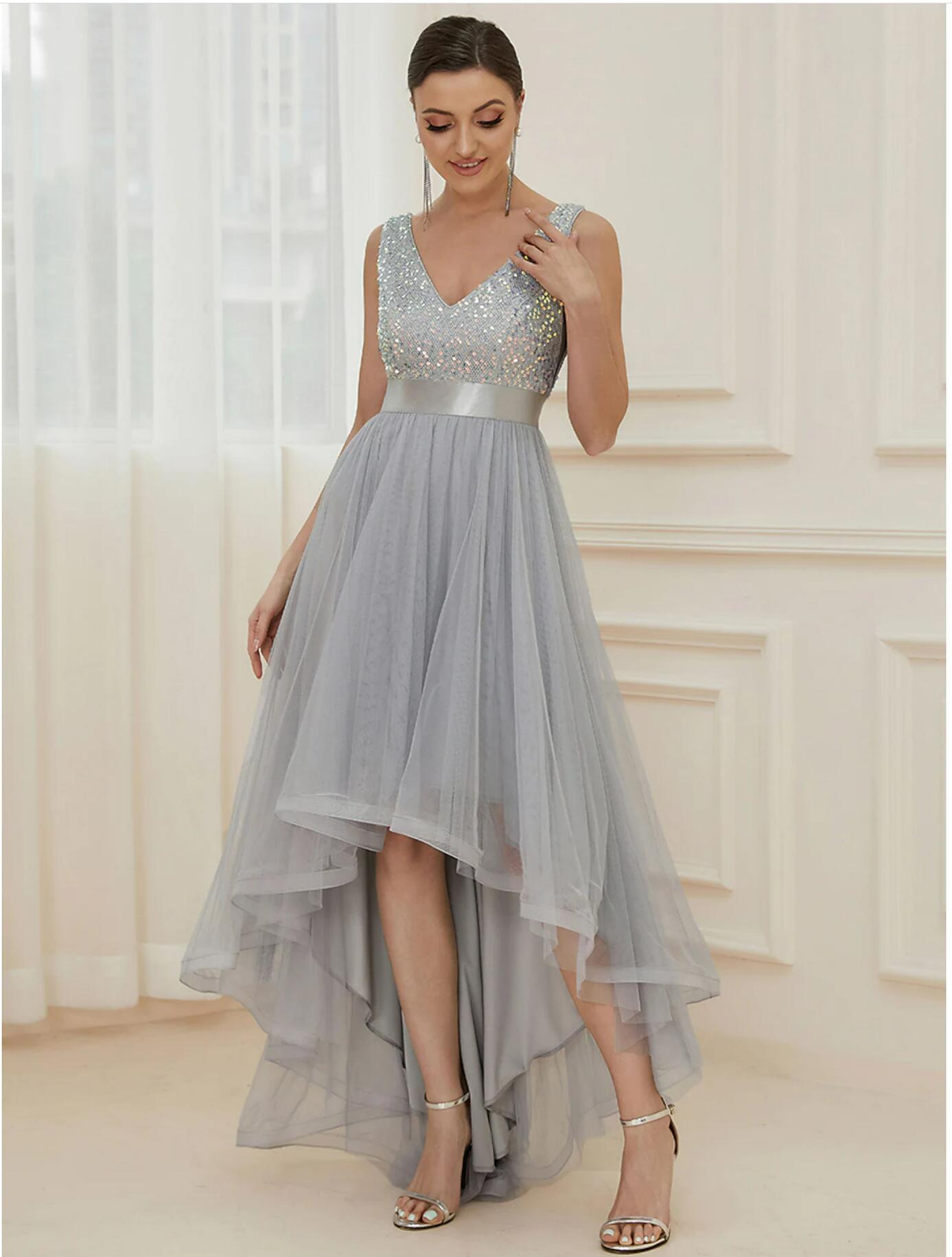 Woman wearing a long, shimmering A-line sequined bridesmaid dress with an asymmetrical hem and V-neck.
