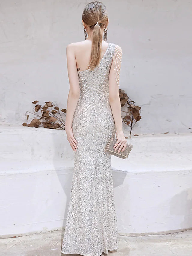 Full length view of a woman wearing a gold sequined mermaid evening gown.