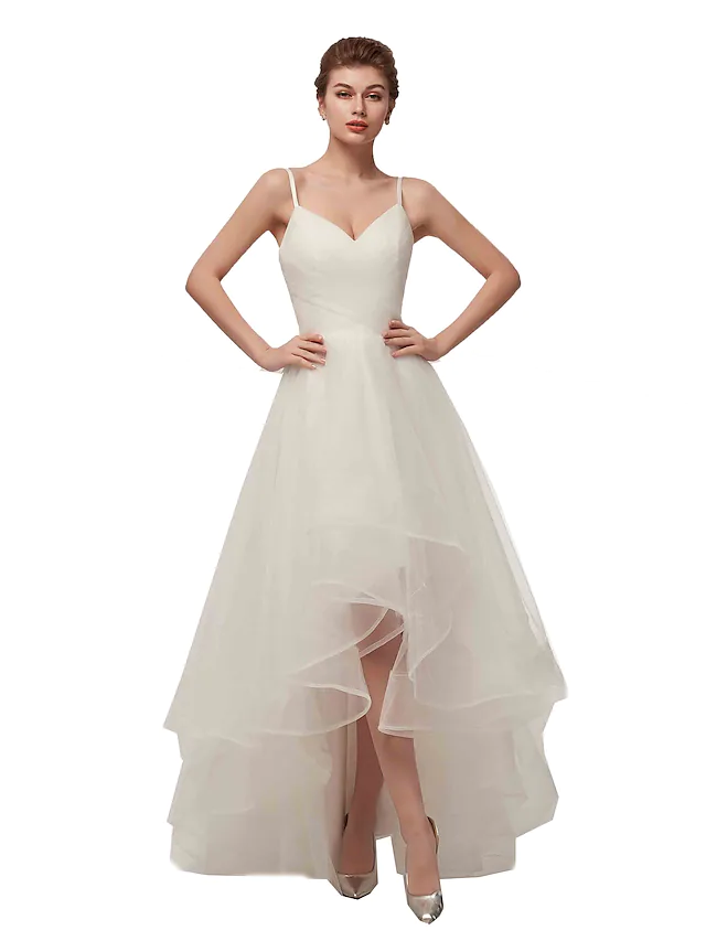 Side view of the A-line white wedding dress, highlighting the asymmetrical hem and tulle fabric.