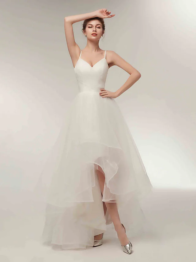 Close-up of the V-neck and spaghetti strap detail on the white wedding dress.