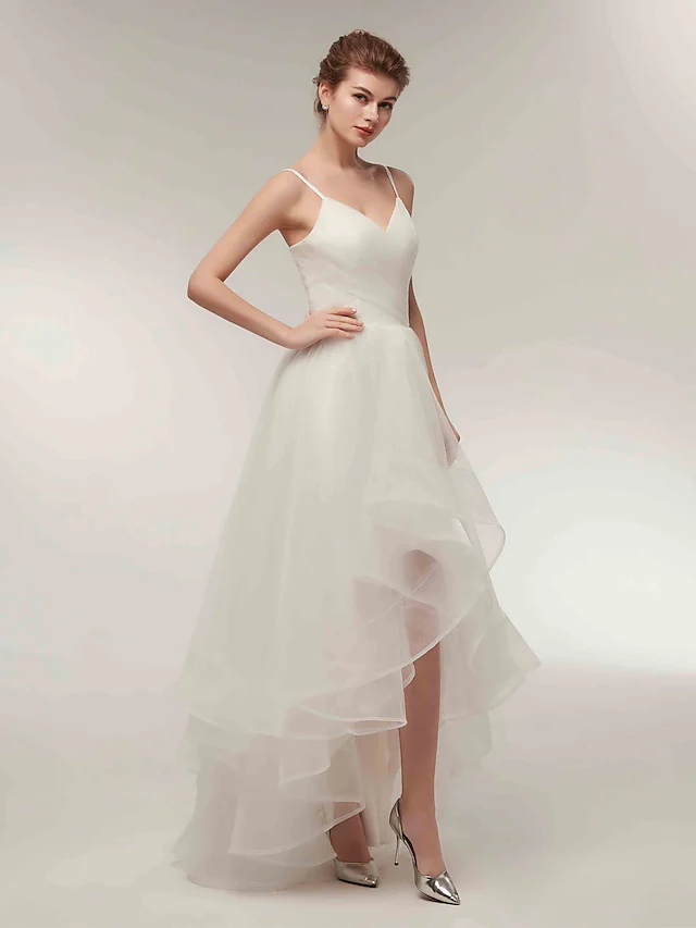 Full length view of the white asymmetrical wedding dress, showcasing its flowy tulle skirt.