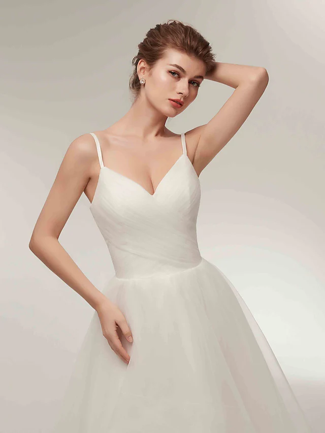 Model posing in the simple white A-line wedding dress with an elegant and casual feel.