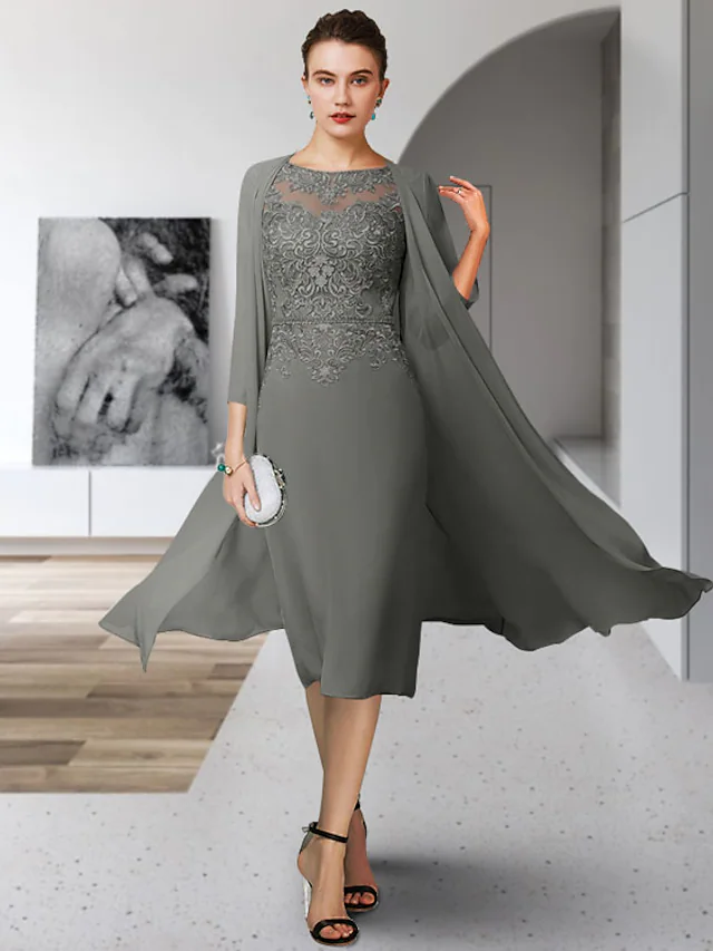 Woman wearing an elegant tea-length Mother of the Bride dress with jewel neck and lace appliques.