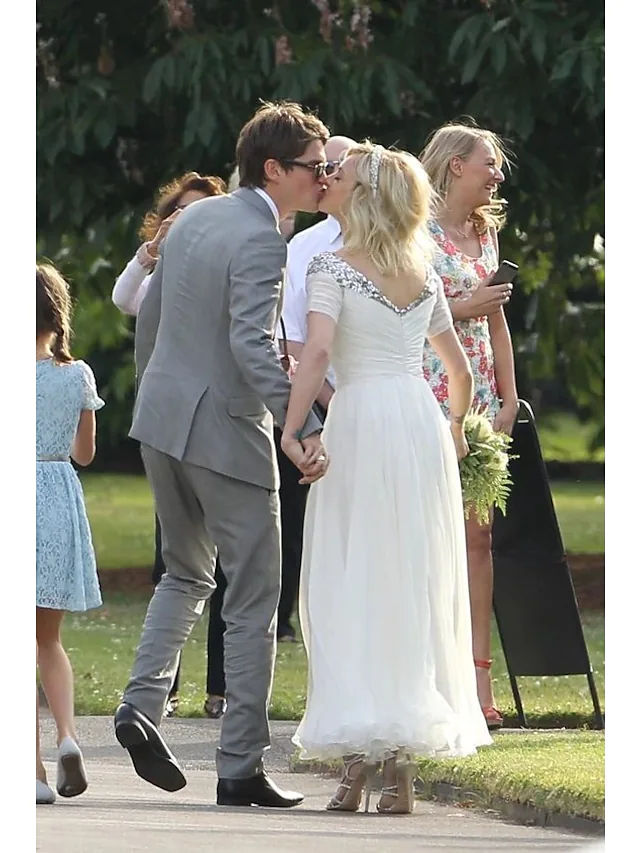 Back view of a model wearing a chiffon sequined A-Line wedding dress with short sleeves.
