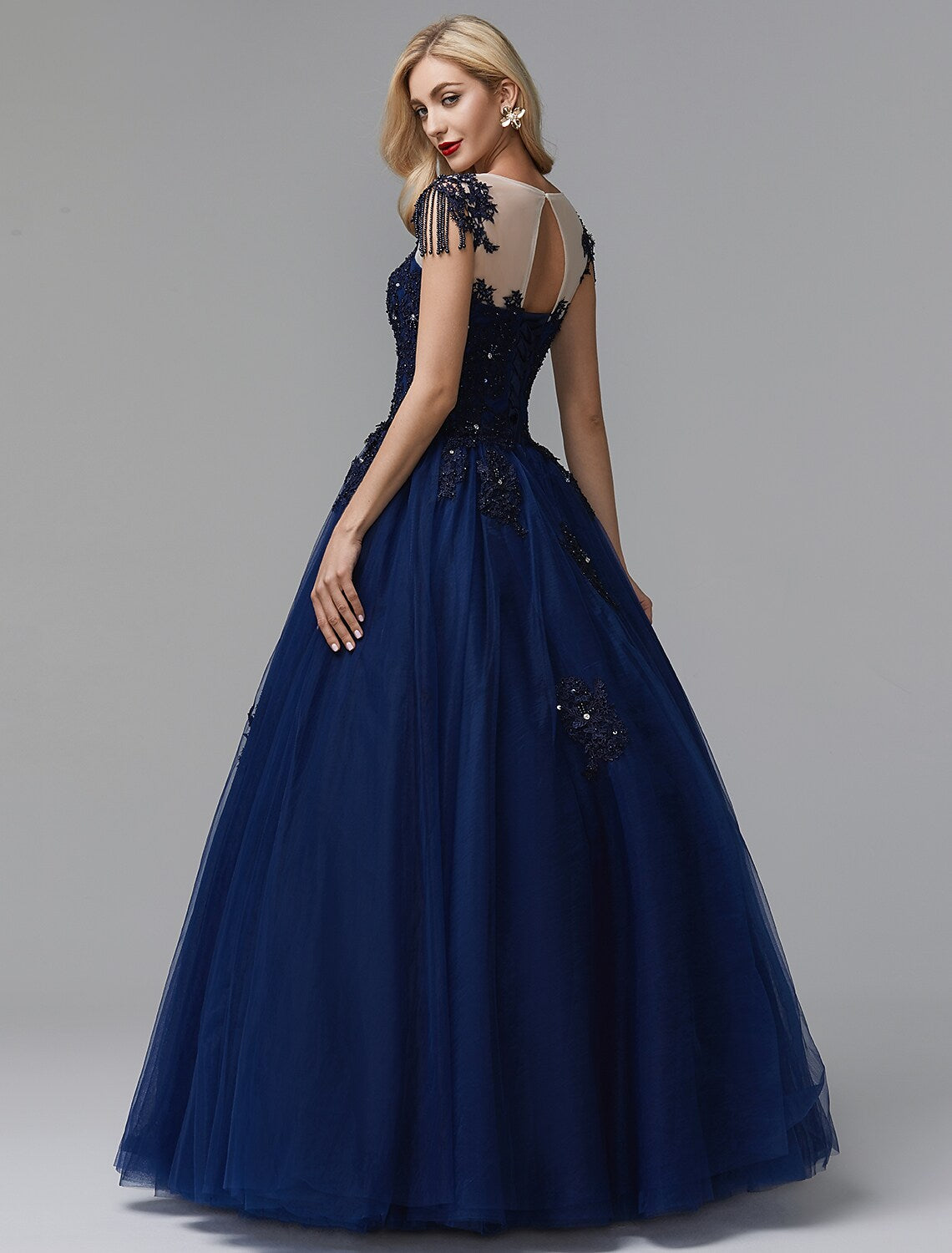 Side view of a model in a sparkling off-shoulder long sleeve prom dress.