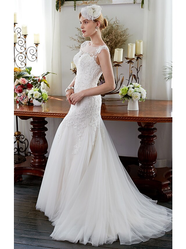Side view of a beaded tulle mermaid wedding gown.