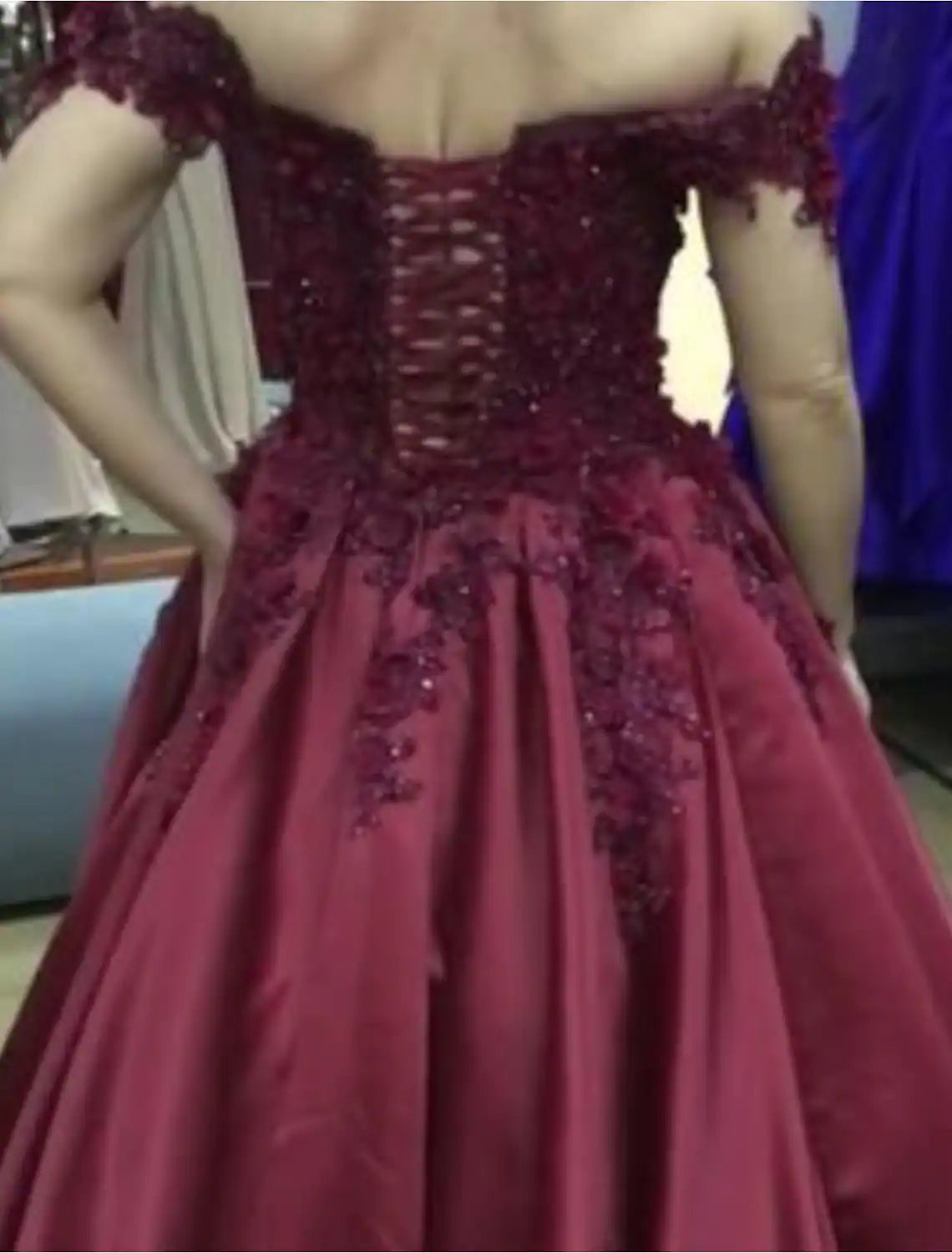 Side view of a floor-length sparkling ball gown with off-shoulder design.