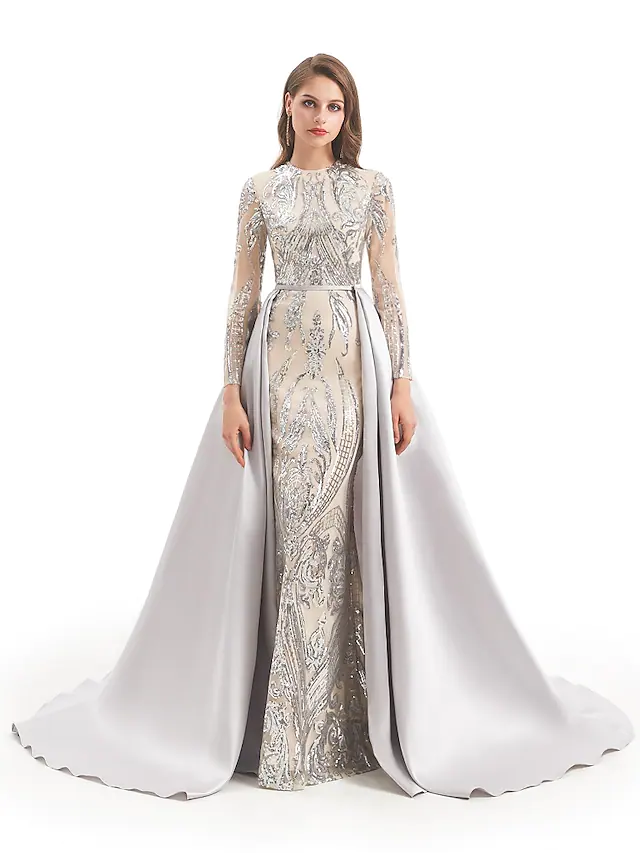 Woman in sparkling sequined ball gown with jewel neck and long sleeves.