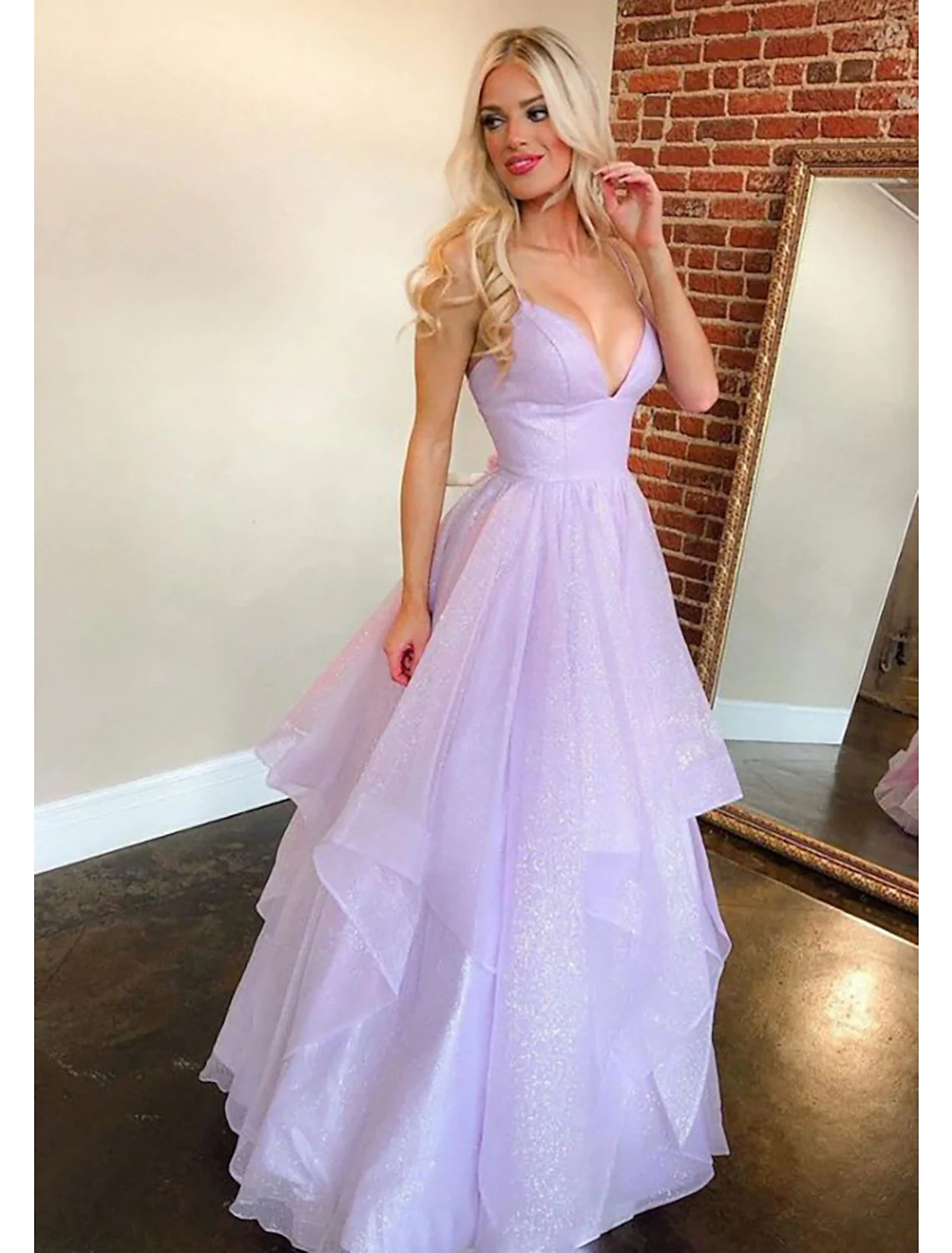 Back view of the sleeveless, backless ball gown, highlighting ruffles.